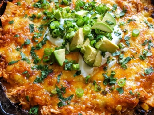 One Skillet Buffalo Ranch Chicken Enchilada Bake topped with cheese and garnished.