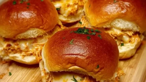 Plate of spicy buffalo chicken sliders garnished with celery and blue cheese