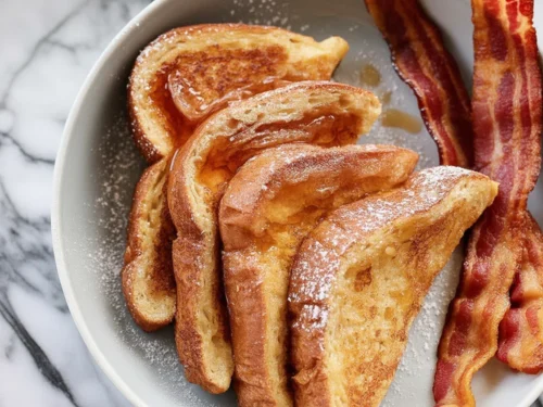 Delicious fluffy French toast made with eggs, milk, and sugar served on a plate.