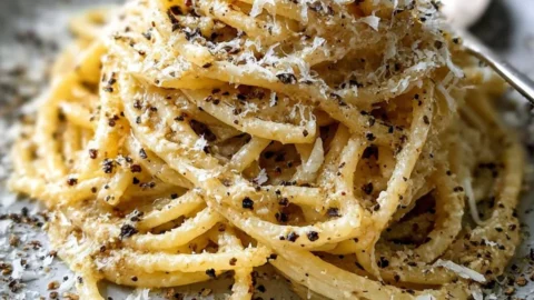 Bowl of gluten-free cacio e pepe with cheese and pepper seasoning
