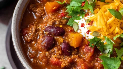 Bowl of hearty pumpkin chili topped with cilantro and cheese