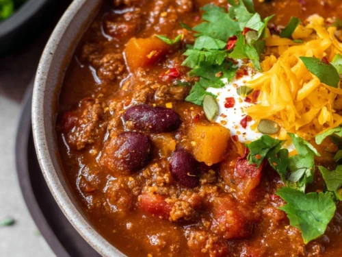 Bowl of hearty pumpkin chili topped with cilantro and cheese