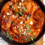 Juicy Roasted Red Pepper Chicken garnished with herbs and served on a plate.